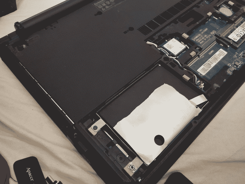 the inside of the laptop, showing the caddy, ssd and single ram stick